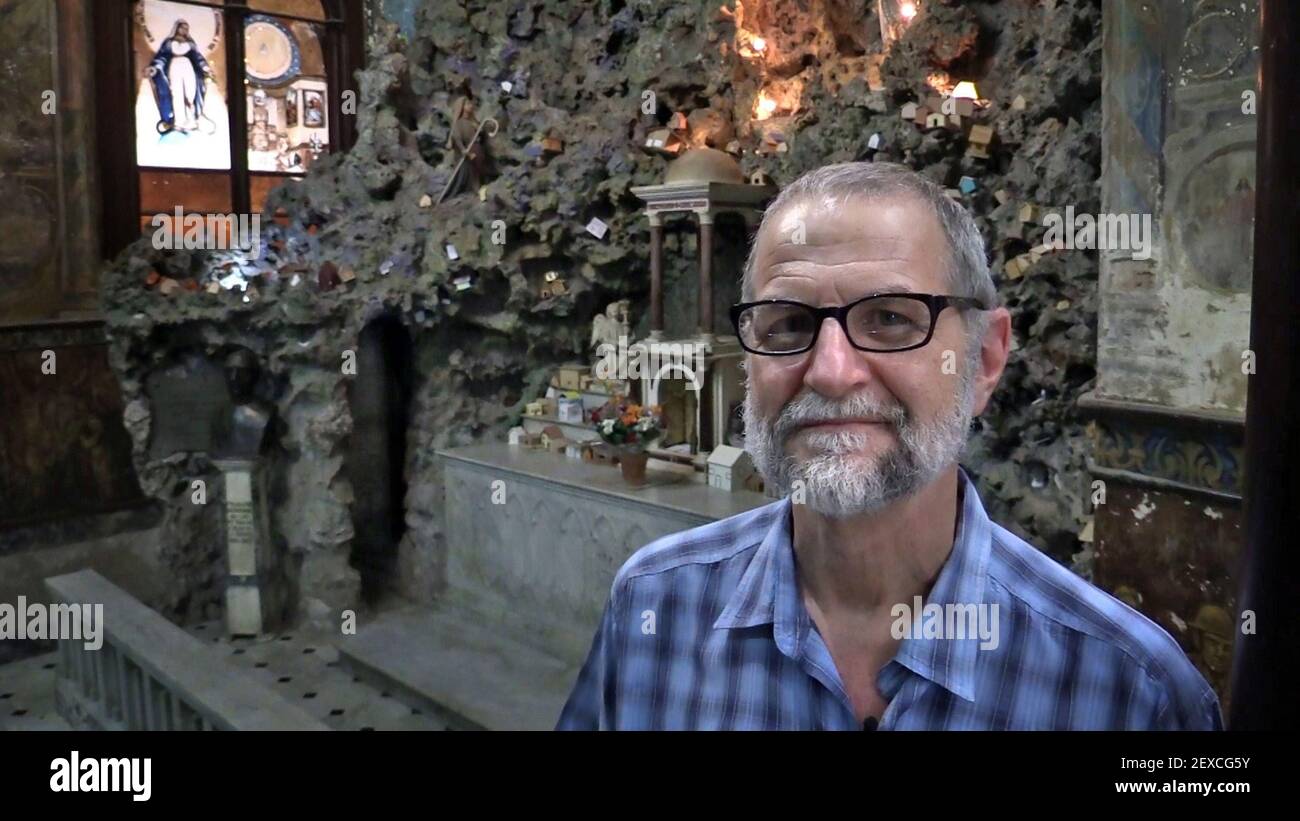 Gilbert Walker, a Vincentian Priest, at La Merced, in Old Havana poses for  a portrait in the grotto in the Church of La Merced where Cuban  parishioners bring miniature, handmade houses and