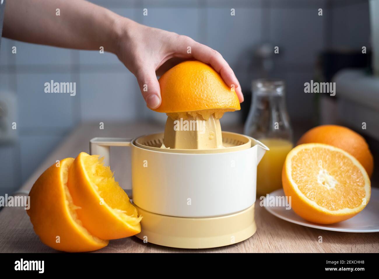 https://c8.alamy.com/comp/2EXCHH8/female-hand-squeezing-orange-juice-from-fresh-oranges-with-a-juicer-in-the-home-kitchen-lose-up-2EXCHH8.jpg