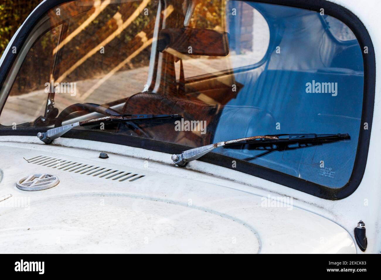 Close up of the windscreen and wipers of a dirty white-painted Volkswagen Beetle car, London, UK Stock Photo