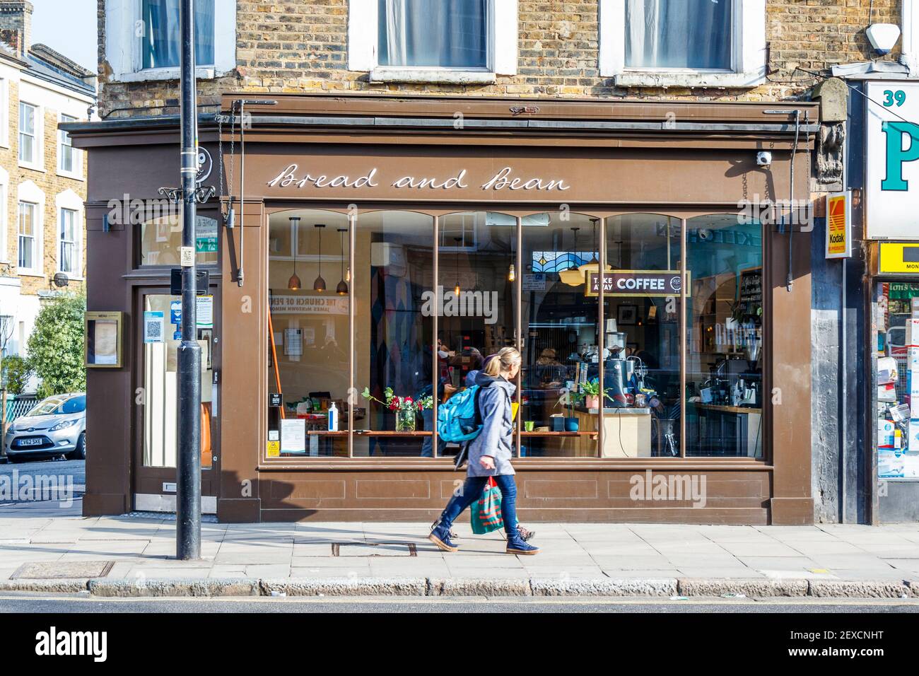 Two women walk past Bread And Bean, an independent coffee shop, open for takeaway only during the third coronavirus lockdown, Islington, London, UK Stock Photo