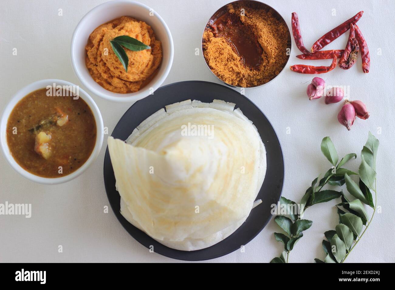 Crispy thin ghee dosa with sambar, coconut chutney and Molaha Podi. Dosa is served in tent shape. A South Indian breakfast. Shot on white background Stock Photo