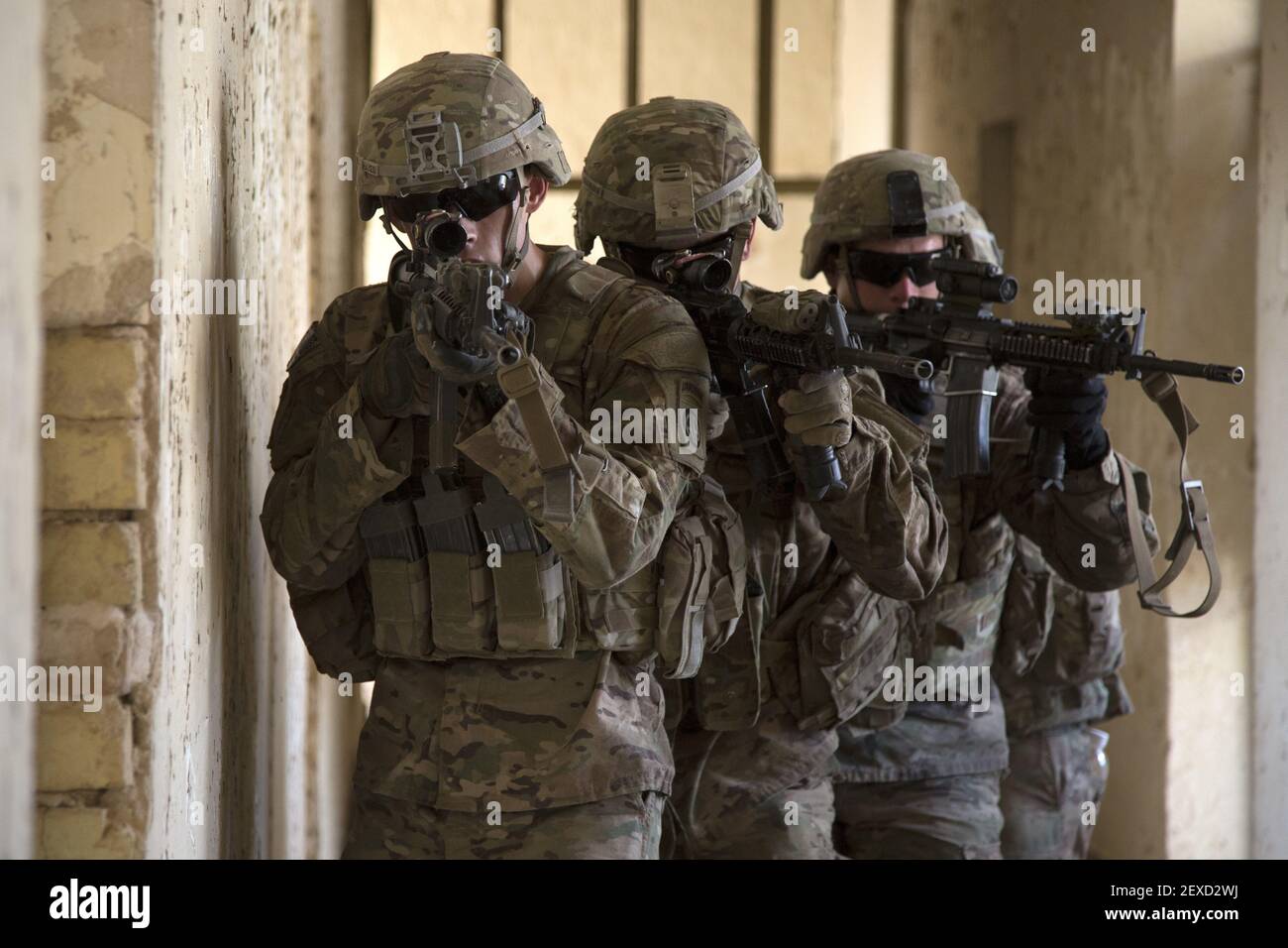 U.S. Army paratroopers assigned to Bravo Troop, 5th Squadron, 73rd Cavalry Regiment, 3rd Brigade, 82nd Airborne Division, maneuver through a hallway as part of squad level training at Camp Taji, Iraq, Aug. 3, 2015. Coalition forces routinely practice what they plan to teach Iraqi soldiers prior to each round of instruction. Training at the building partner capacity sites is an integral part of Combined Joint Task Force – Operation Inherent Resolve’s multinational effort to train Iraqi security force personnel to defeat the Islamic State of Iraq and the Levant. A coalition of regional and i Stock Photo