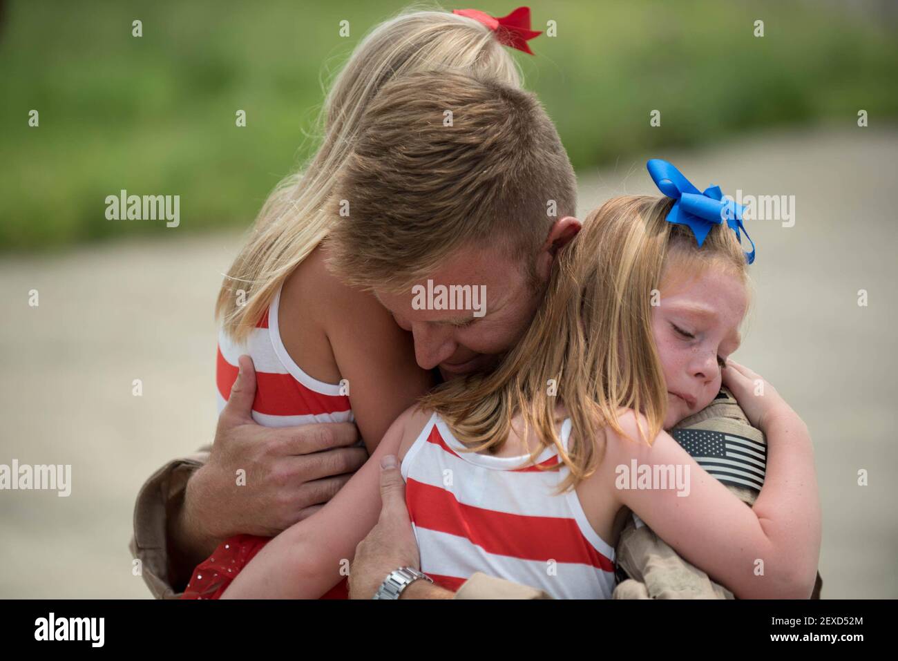 Capt. Ross Farling, a C-130 Hercules pilot from the 123rd Airlift Wing, hugs his daughters during a homecoming ceremony at the Kentucky Air National Guard Base in Louisville, Ky., July 4, 2015. Farling was among 39 guardsmen who returned from a deployment to the Persian Gulf region, where they supported Operation Freedom's Sentinel. (Photo by Maj. Dale Greer/U.S. Air National Guard) *** Please Use Credit from Credit Field *** Stock Photo