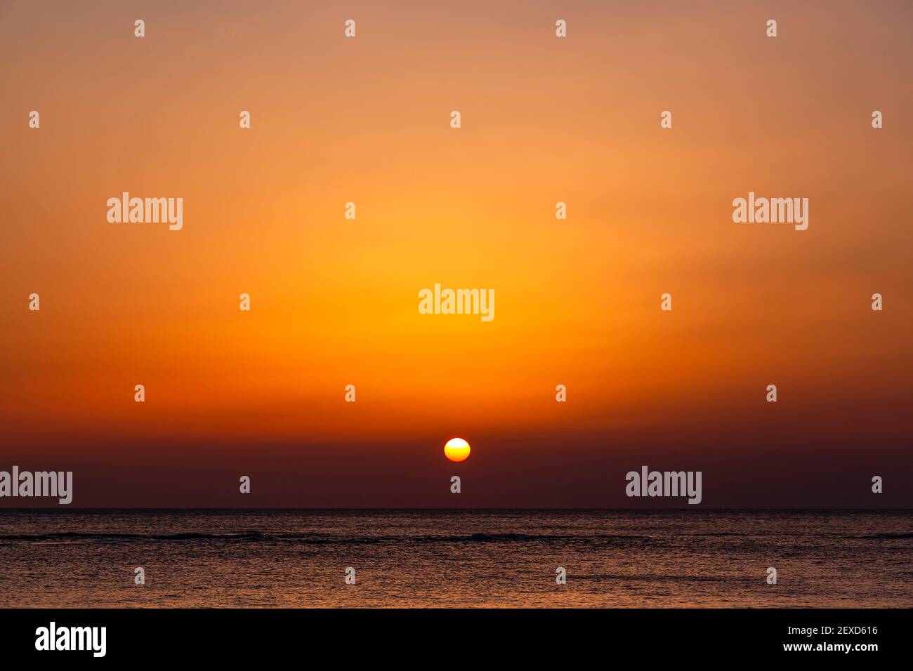 Bright sunset with a big yellow sun under the sea surface. Stock Photo
