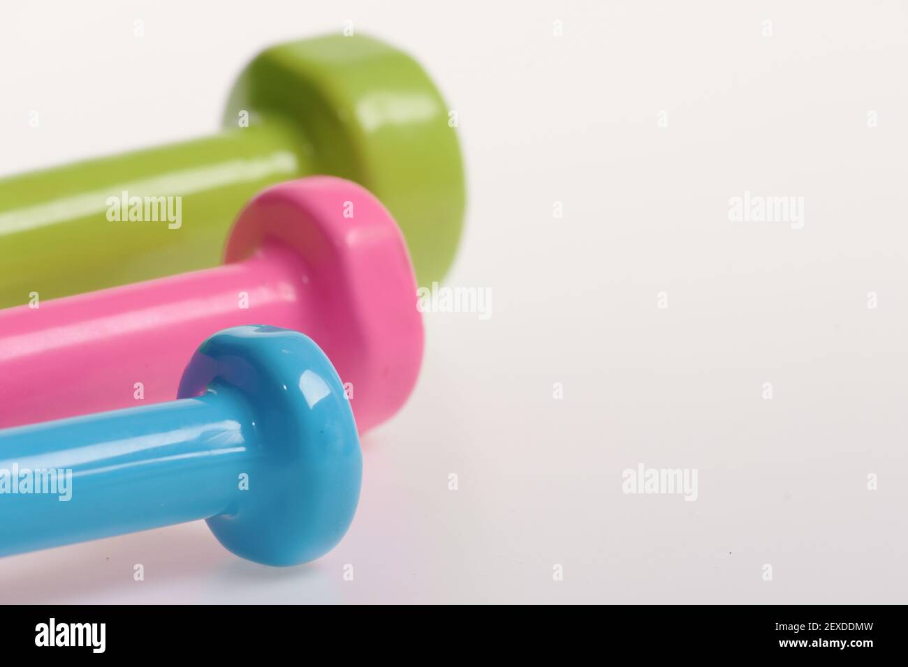 Sport regime and fitness symbols. Barbells in pink, green and blue colors,  close up. Healthy lifestyle