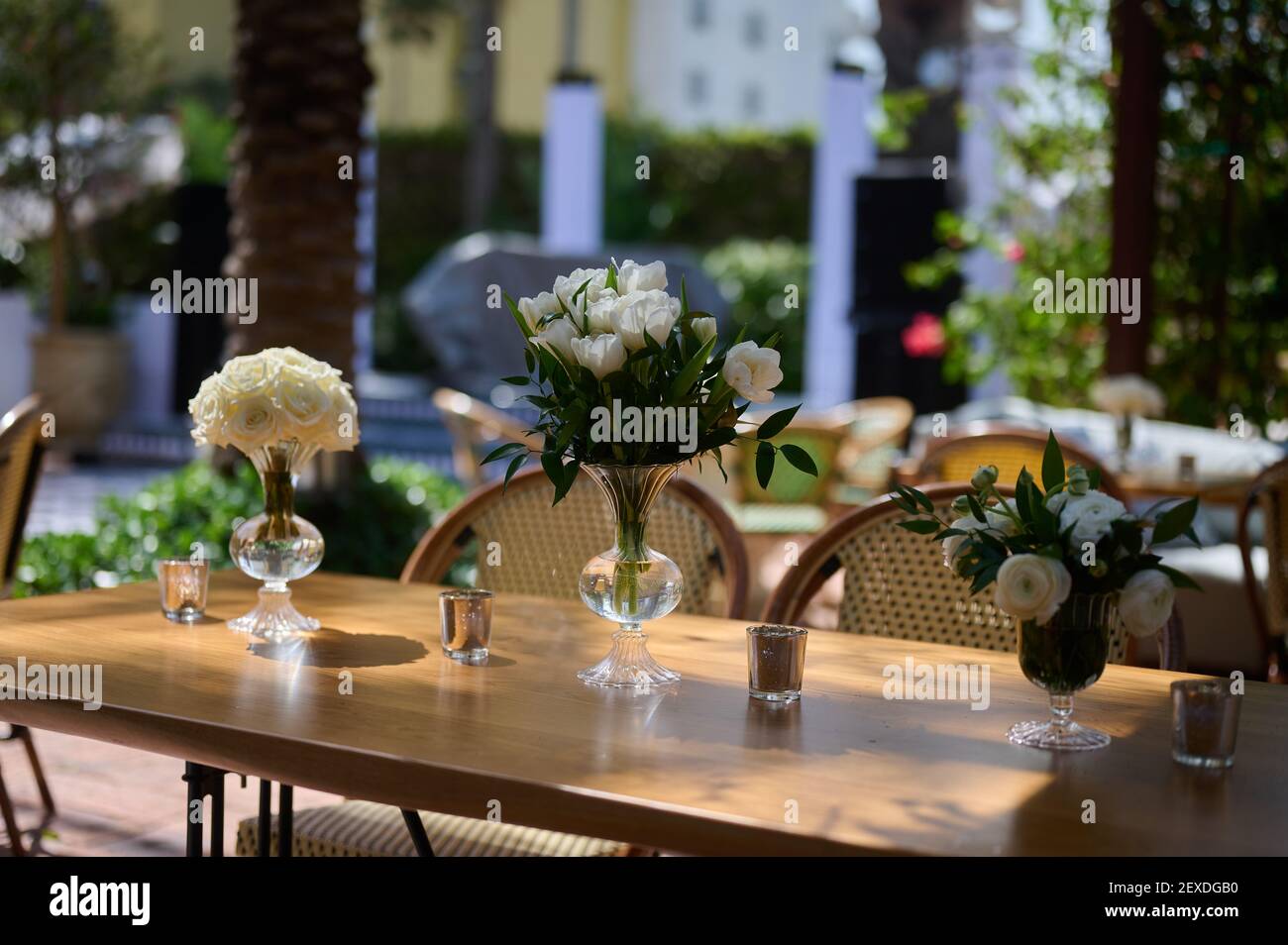Table setting with vases with flowers and candles Stock Photo - Alamy