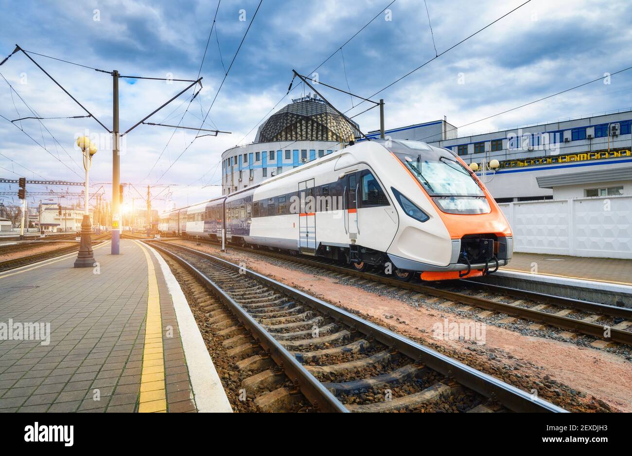 High speed train on the railway station at sunset Stock Photo
