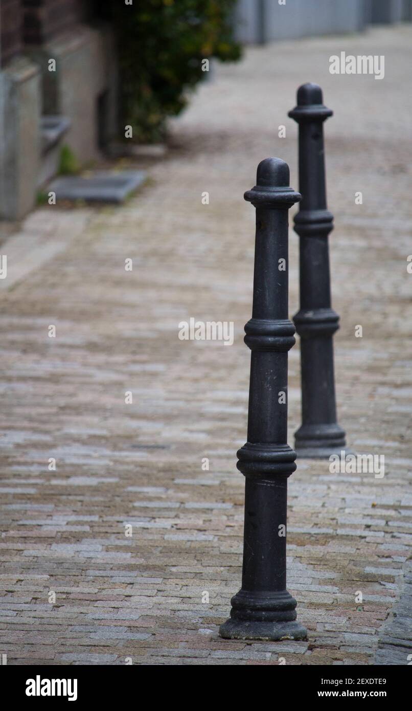 A closeup of black cast iron bollards installed in the middle of the street Stock Photo