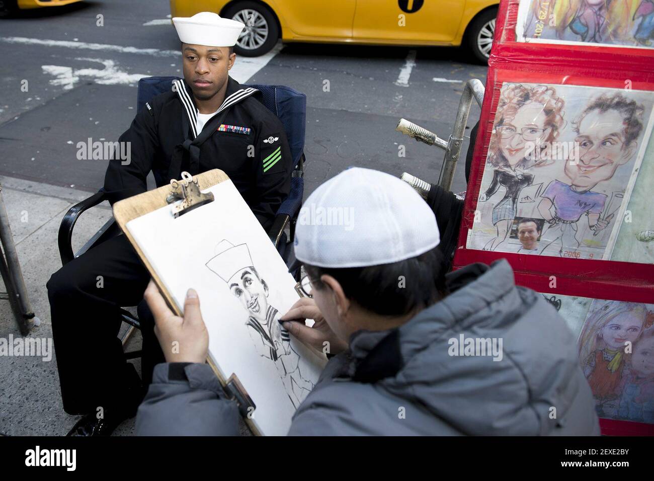 NEW YORK (Nov. 9, 2015) USS New York (LPD 21) Sailor Airman Aaron Waters gets a caricature drawn while visiting New York Cityâ€™s Times Square. New York is participating in Veterans Week New York City to honor the service of all our nationâ€™s veterans. The ship conducted training certification during its transit from its homeport in Mayport, Fla. (Photo by Mass Communication Specialist 1st Class Brian McNeal/U.S. Navy) *** Please Use Credit from Credit Field *** Stock Photo