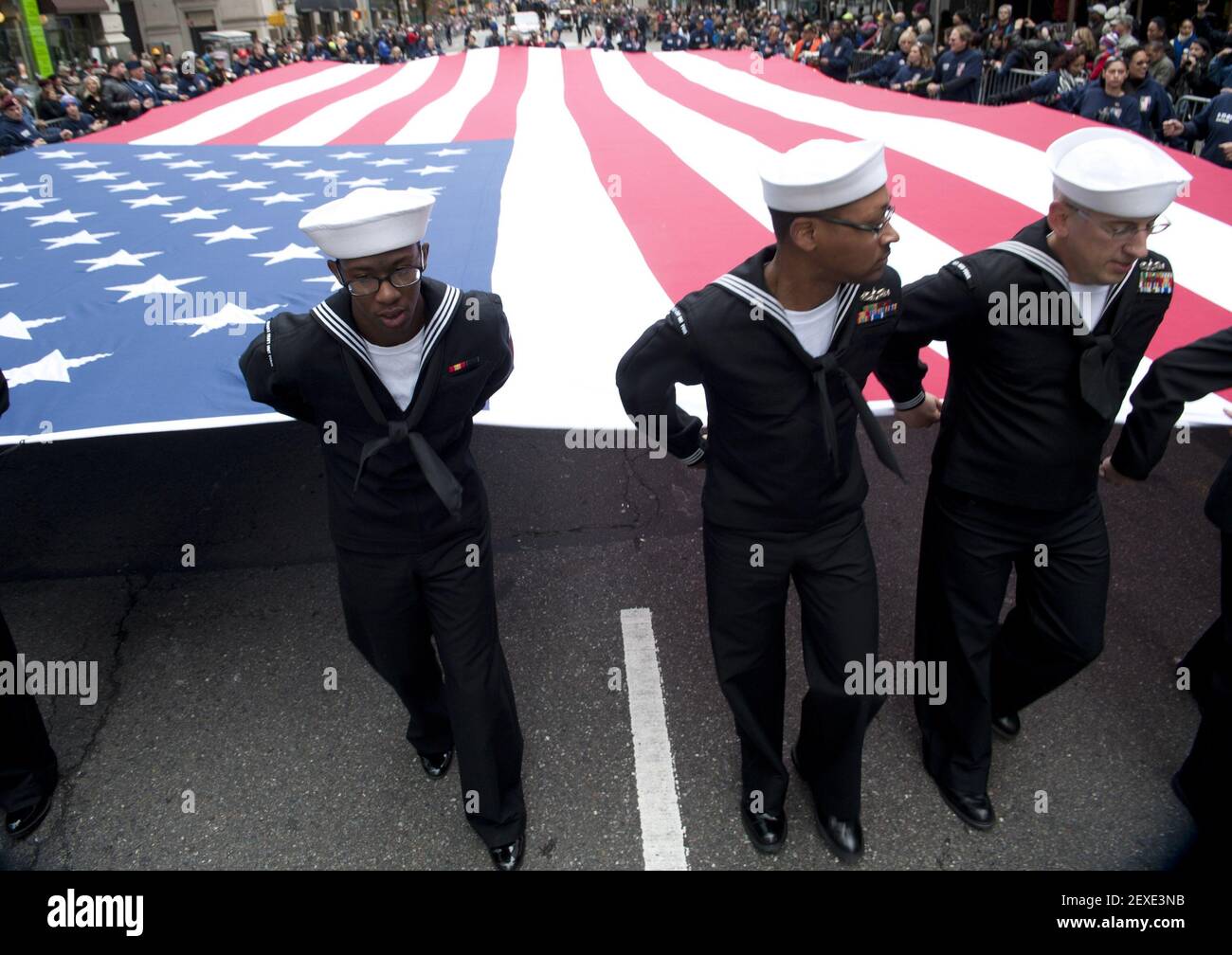 NEW YORK (Nov. 11, 2015) Sailors hold the national ensign as they march during the NYC Veterans Day Parade. (Photo by Mass Communication Specialist 1st Class Martin L. Carey/U.S. Navy) *** Please Use Credit from Credit Field *** Stock Photo