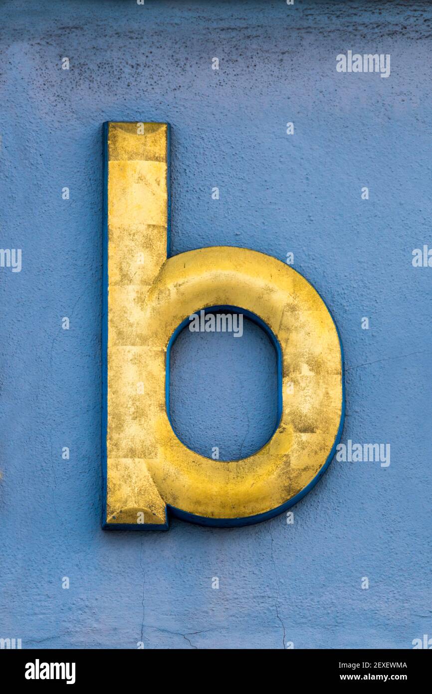 Golden letter b on a blue wall Stock Photo