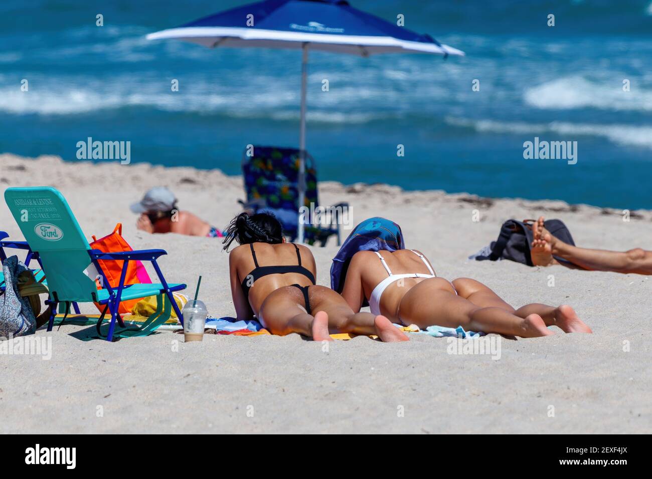 Girls on Fort Lauderdale Beach texting during Spring Break 2021 Stock