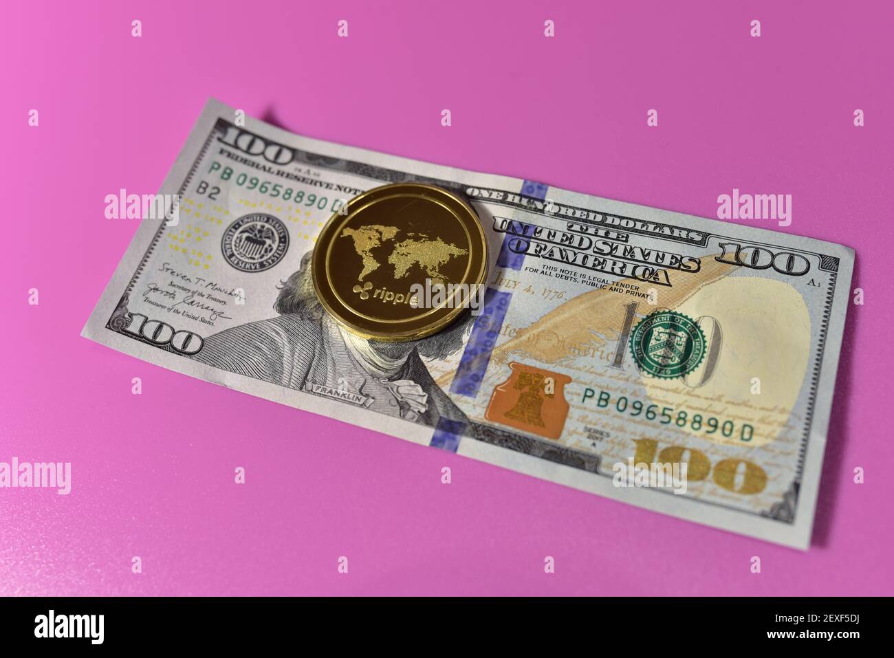 Ripple XRP Gold crypto on the one hundred dollar bills. Ripple XRP and  cryptocurrency investing concept. Blockchain and financial technology.  Transact Stock Photo - Alamy