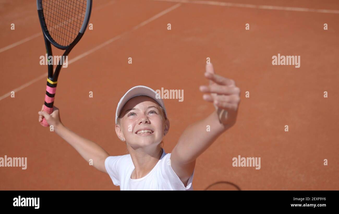 A young tennis player serves in the game. Stock Photo