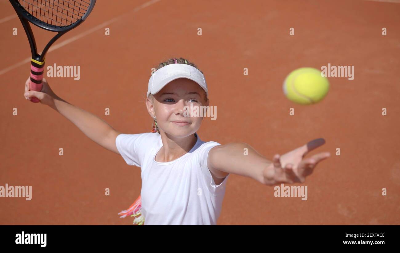 A young tennis player serves in the game Stock Photo Alamy