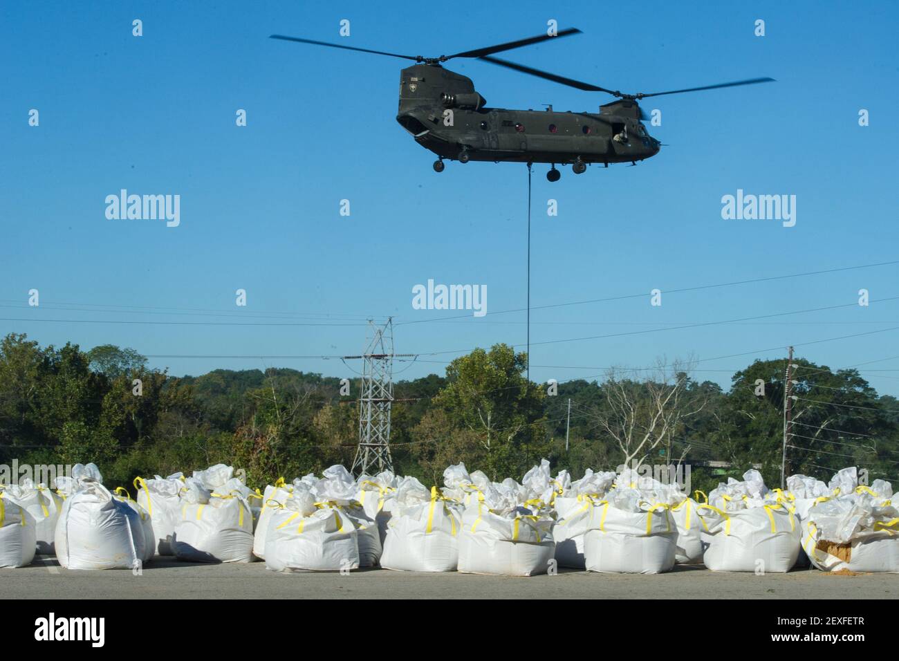 U.S. Soldiers from the 2-238th General Support Aviation Battalion, South Carolina Army National Guard, deliver sandbags with a CH-47 Chinook helicopter to dam the breached canal at the Riverfront Canal Park in Columbia, S.C., Oct. 7, 2015. The South Carolina National Guard has been activated to support state and county emergency management agencies and local first responders as historic flooding impacts counties statewide. Currently, more than 2,600 South Carolina National Guard members have been activated in response to the floods. (Photo by Tech. Sgt. Jorge Intriago/U.S. Air National Guard)  Stock Photo