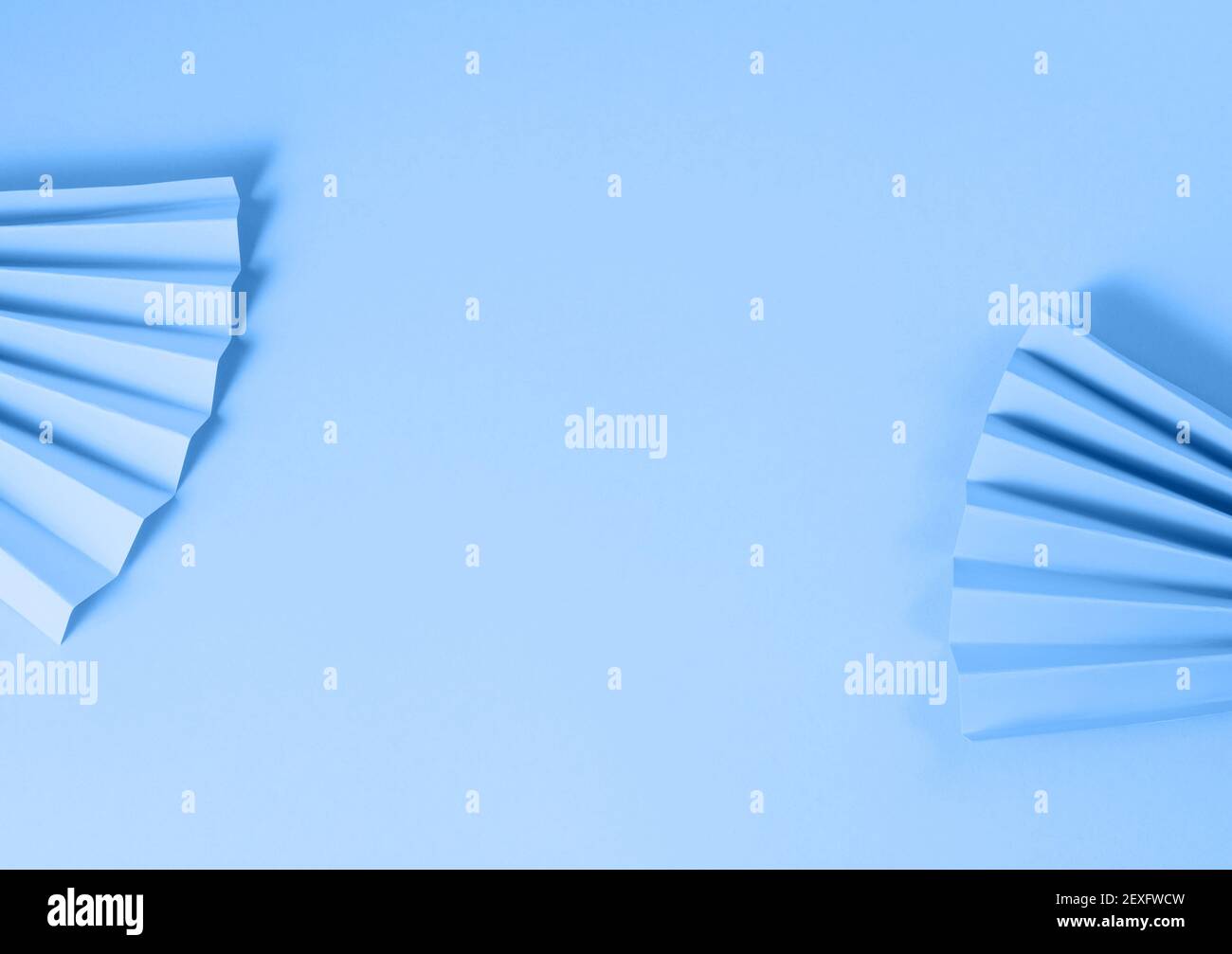Pastel color paper fans on blue background Stock Photo Alamy