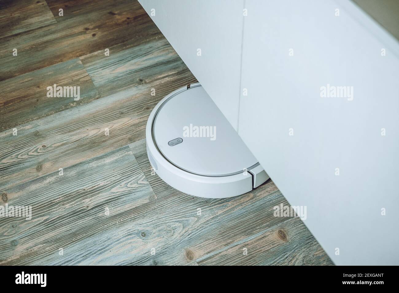 Robotic Vacuums, Robot Mops. Smart home. Automatic robotic vacuum cleaner on laminate wood floor