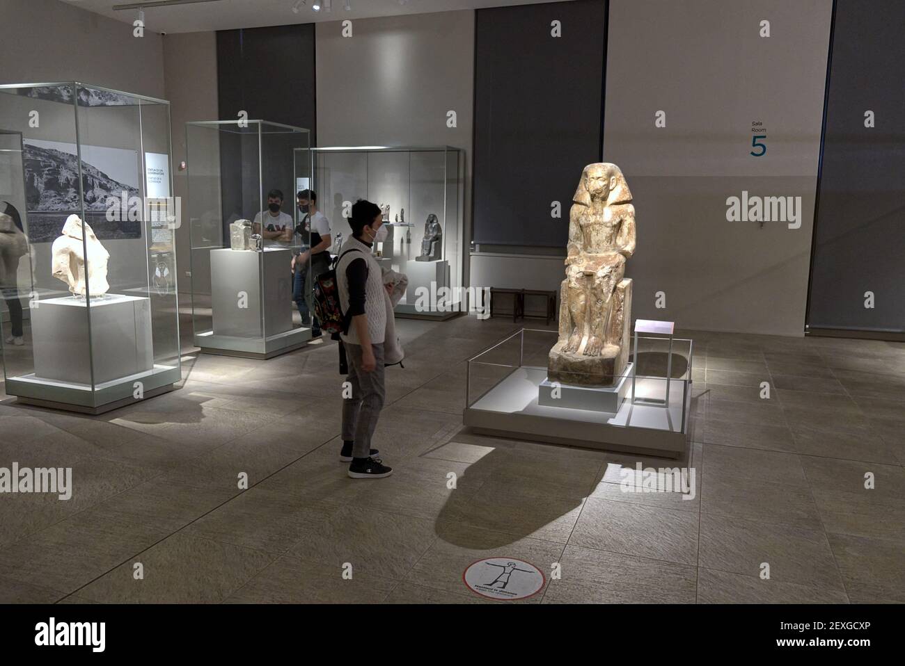 Egyptian museum in Turin, Italy - February 2021: tourists observe the classic stone statues of the imperial era Stock Photo