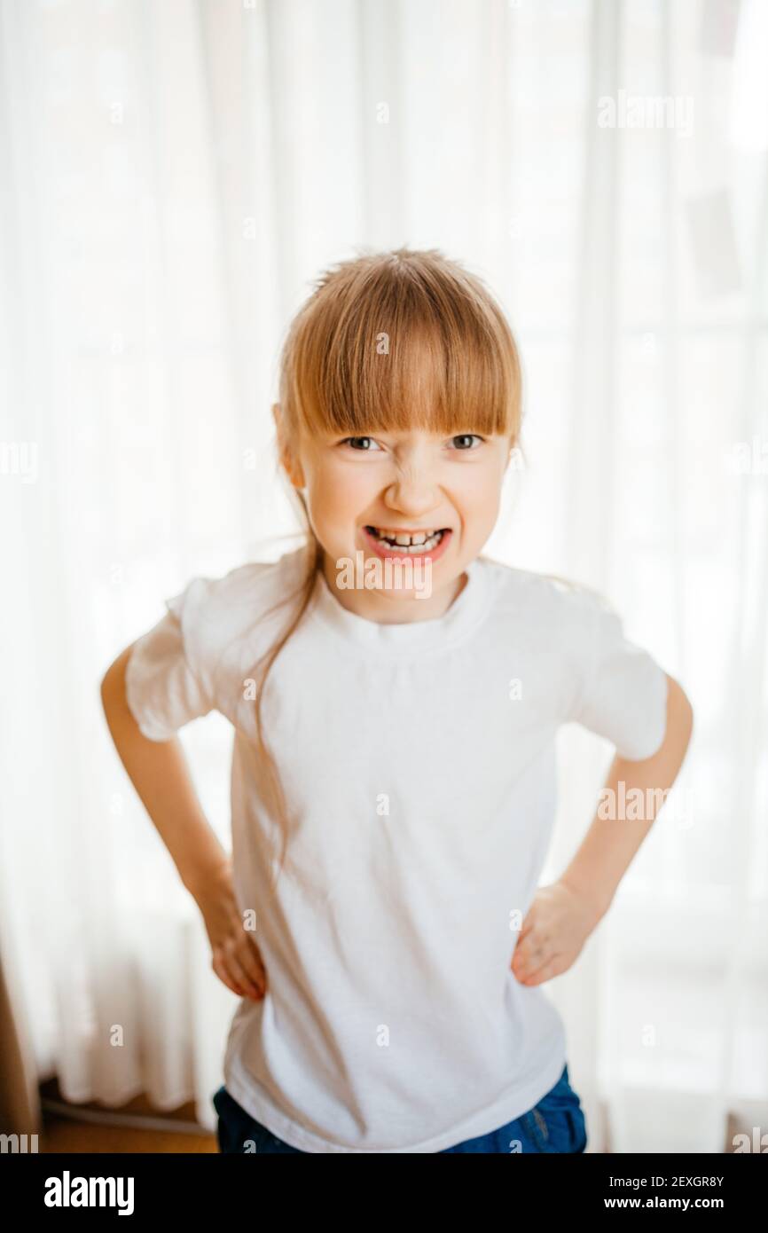 the girl shows her teeth and grimaces Stock Photo