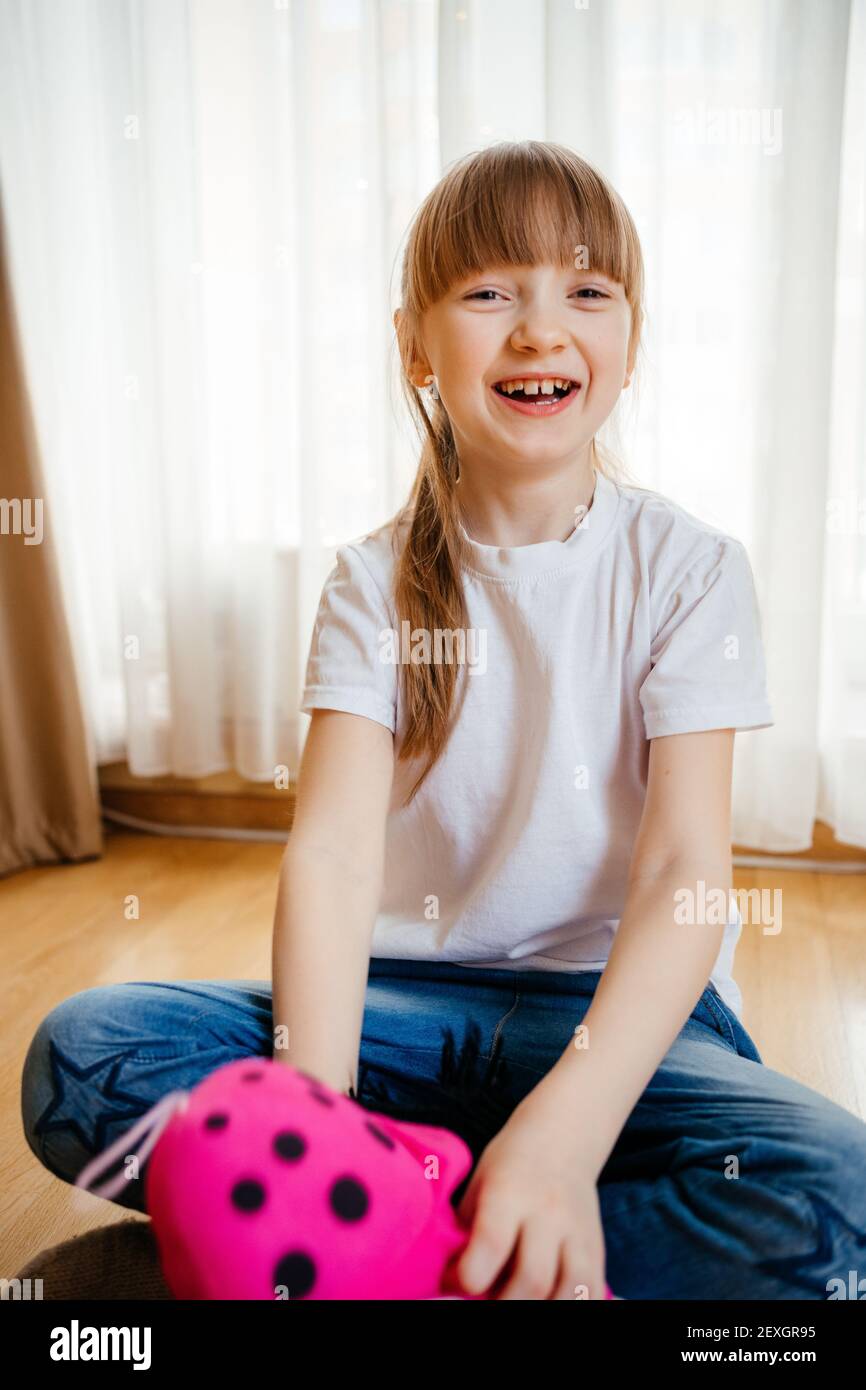 girl playing with dolls on the floor Stock Photo