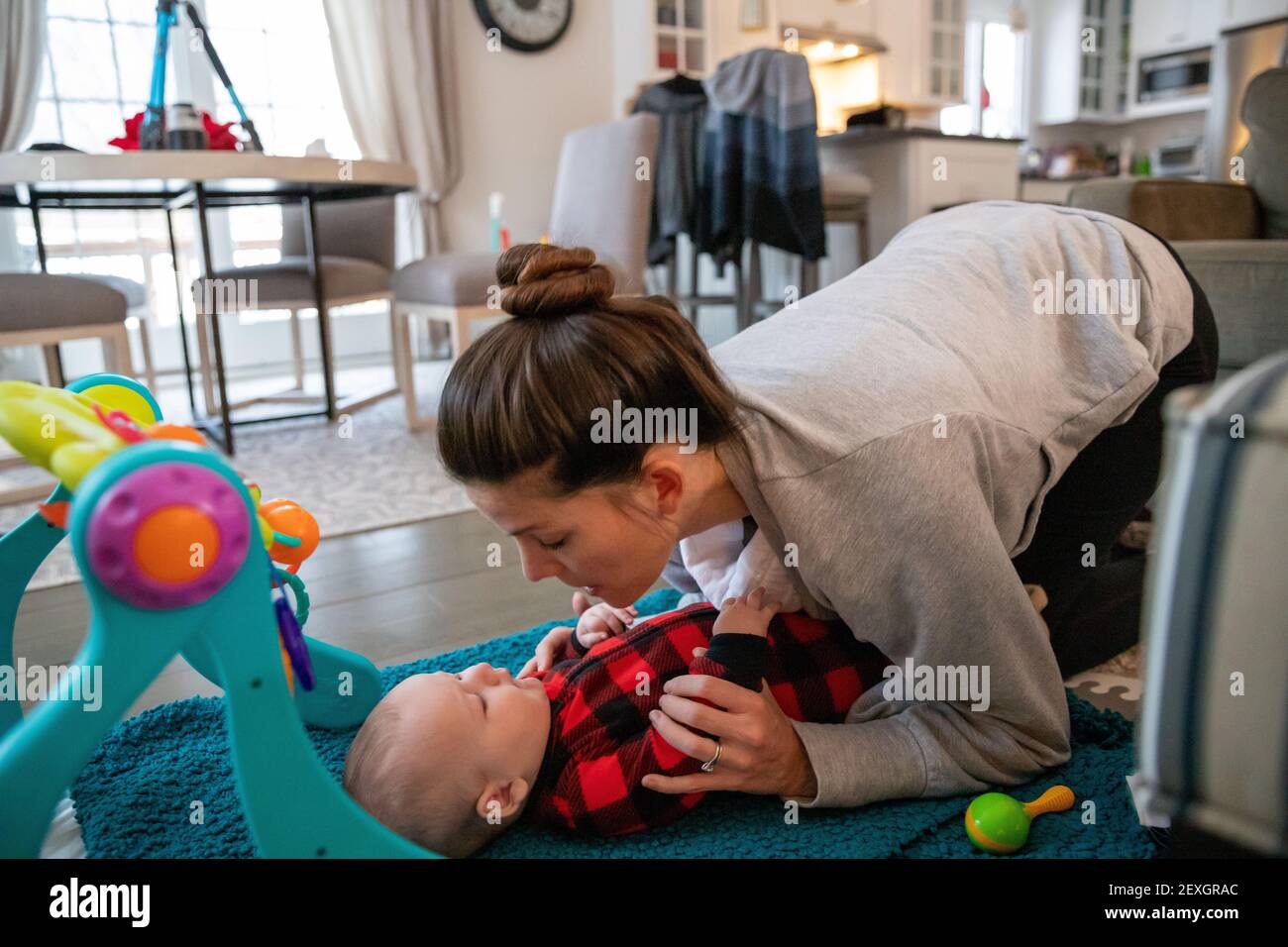 Mother playing with baby in the living room. Stock Photo