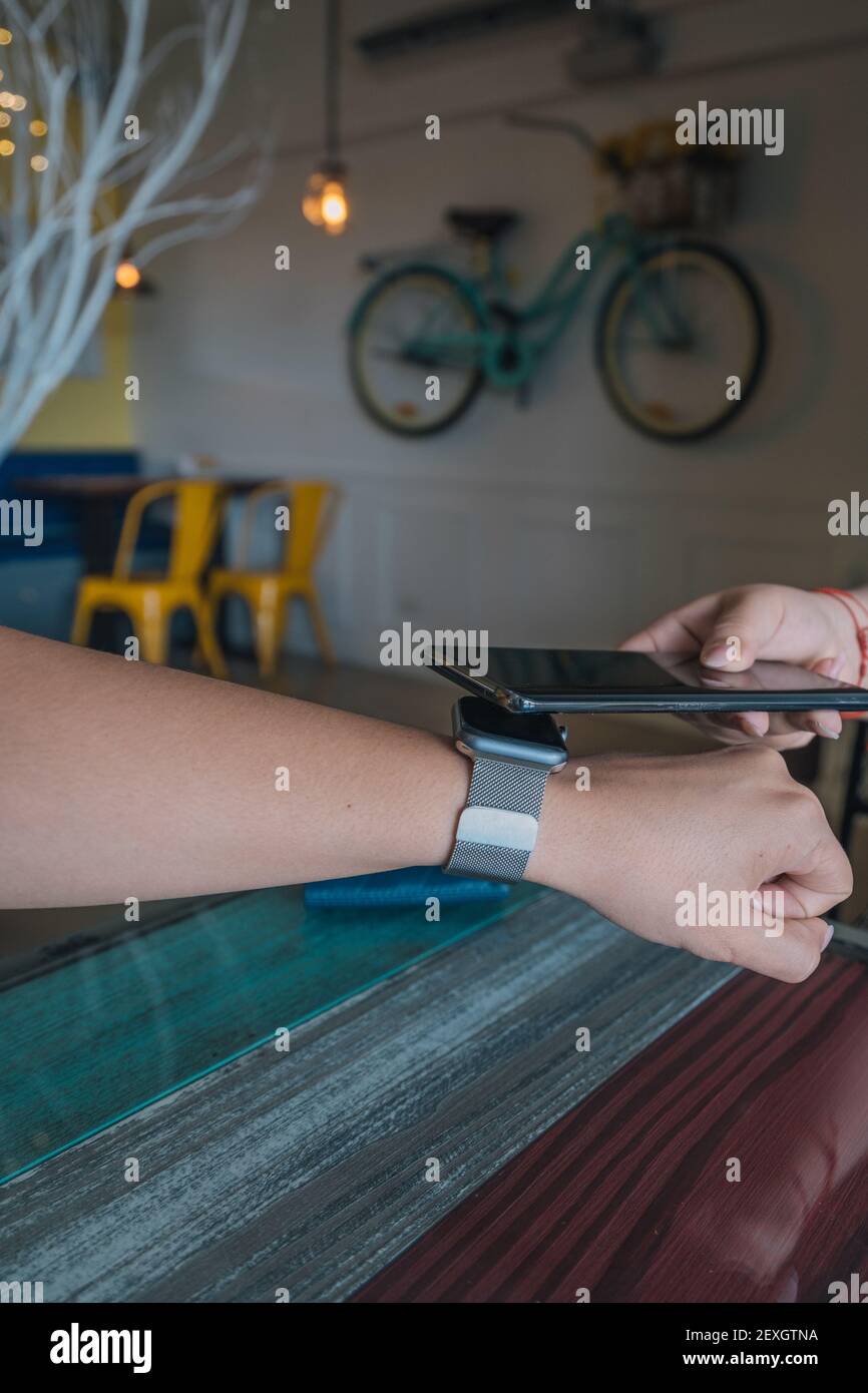 Female Customer Using Smartwatch For NFC Payment Stock Photo