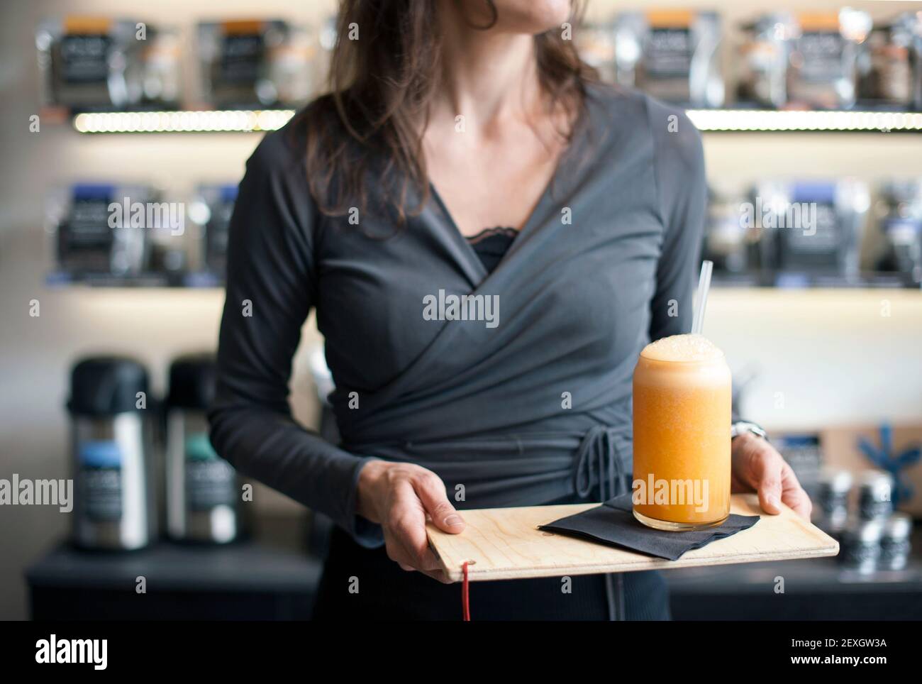 Close-up of serving waitress, hands holding a glass of orange juice on tray. Healthy lifestyle concept Stock Photo