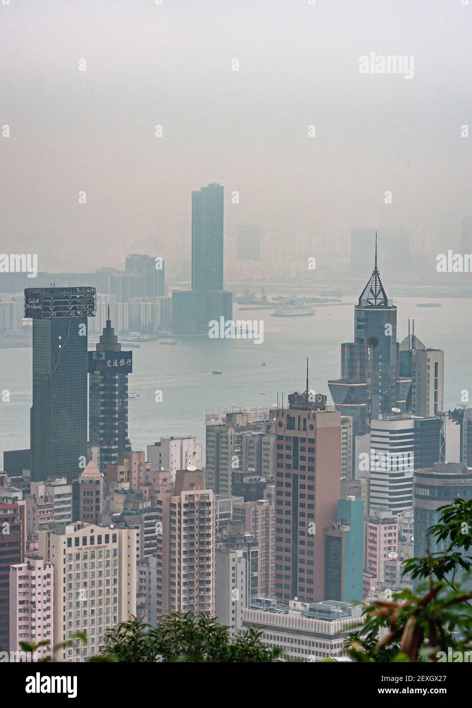 Hong Kong, China - May 12, 2010: Looking down from Victoria Peak on Hong Kong Island and Kowloon cityscape with skyscrapers and Victorial harbor. Fogg Stock Photo
