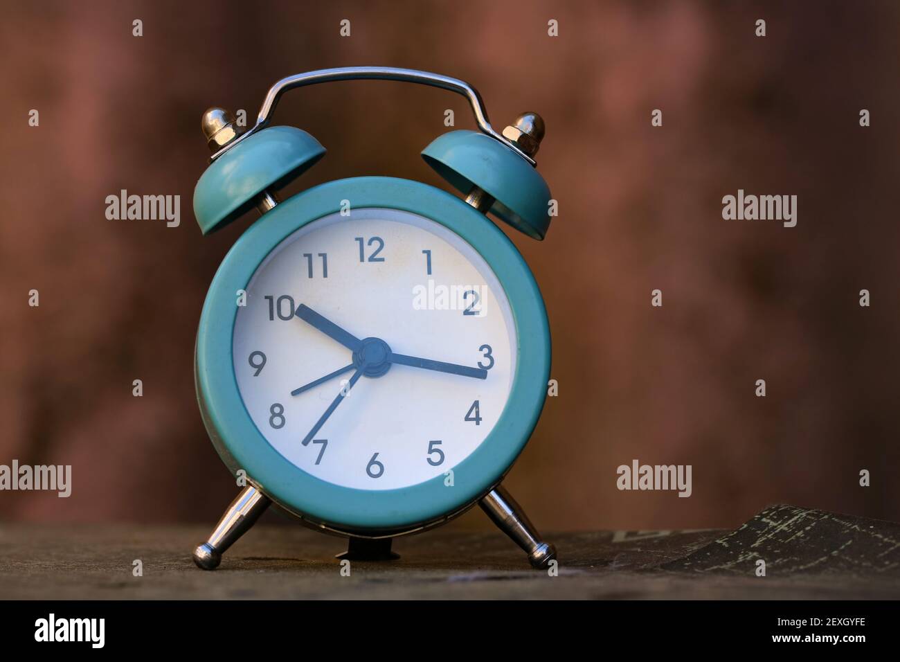 A blue alarm clock on the table Stock Photo