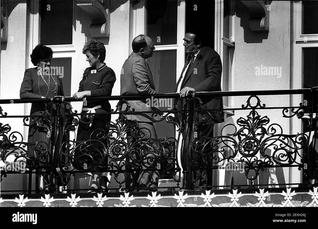 Robert Maxwell deceased former publisher of Mirror Group Newspapers talks with Neil Kinnock a balcony in Brighton while his wife Betty talks to Neil's wife Glenysdbase Stock Photo