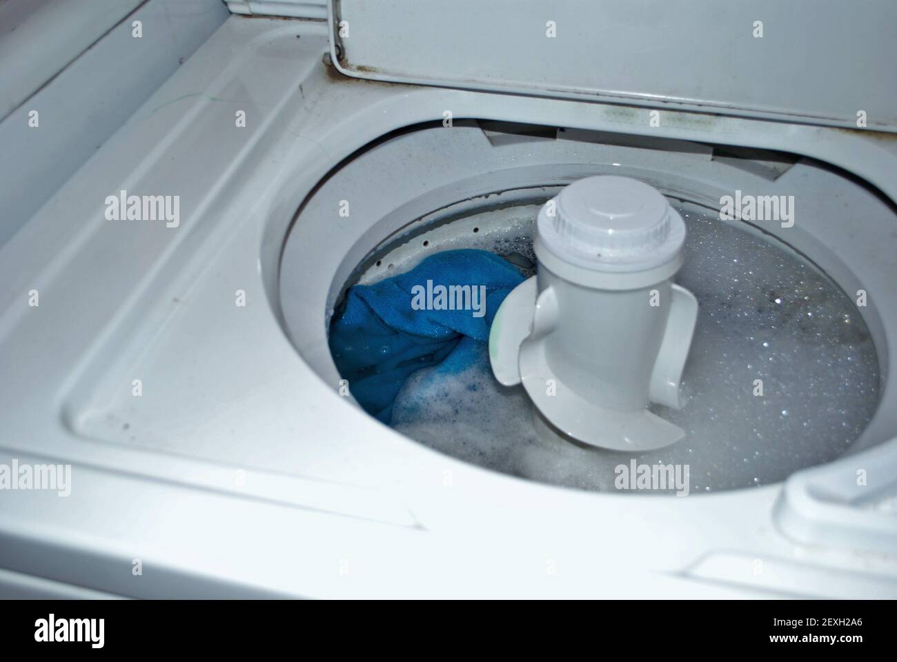 load of dirty towels in a washing machine full of water and soap