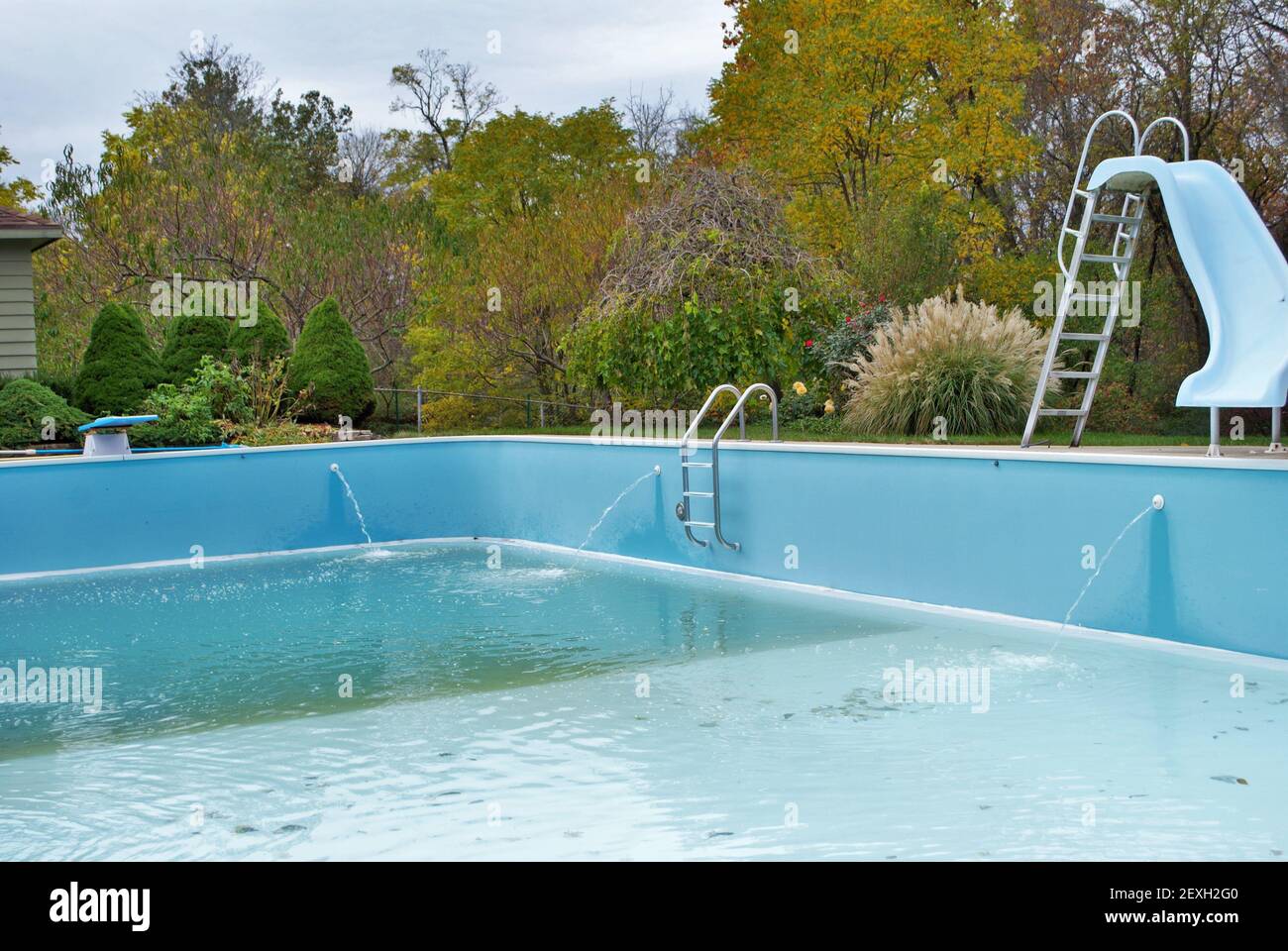 backyard swimming pool with diving board pool slide and ladder emptied out shutting down for