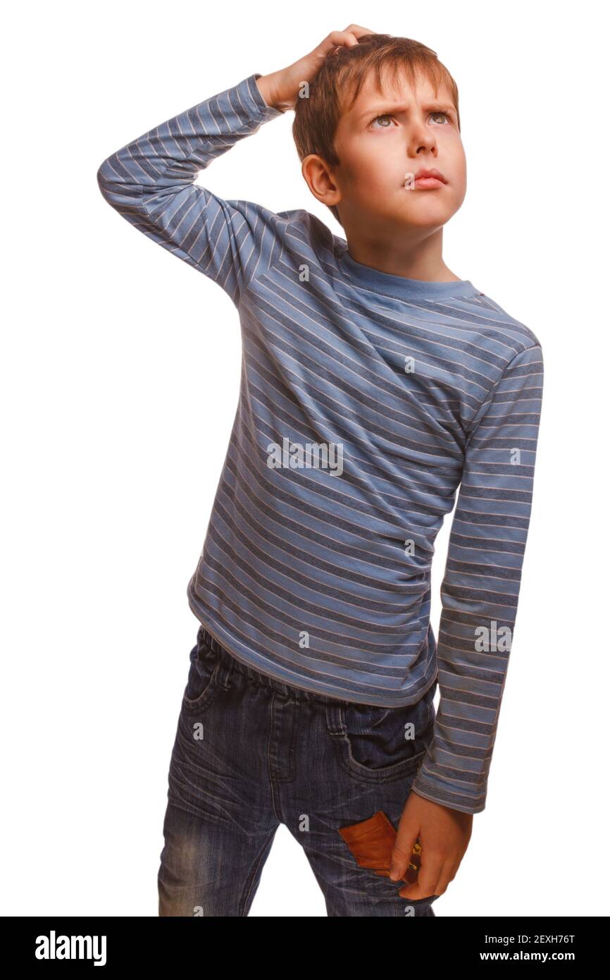 Blond kid boy in a striped sweater thinks scratching his head ha Stock Photo