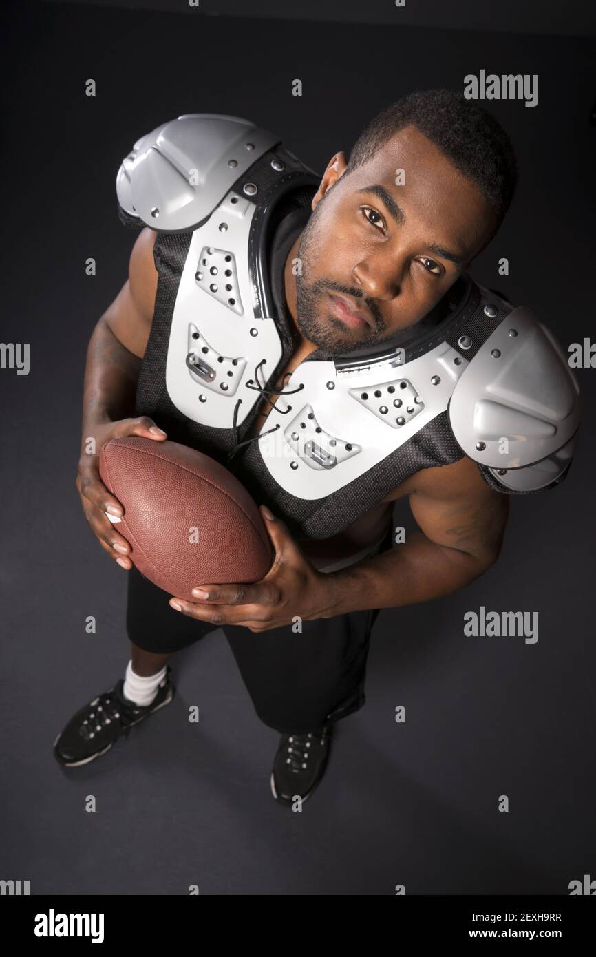 African American Man Football Player Shoulder Pads Looking at Camera