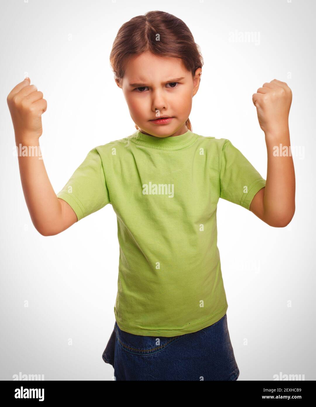 Angry child evil girl shows fists experiencing anger emociones Stock Photo
