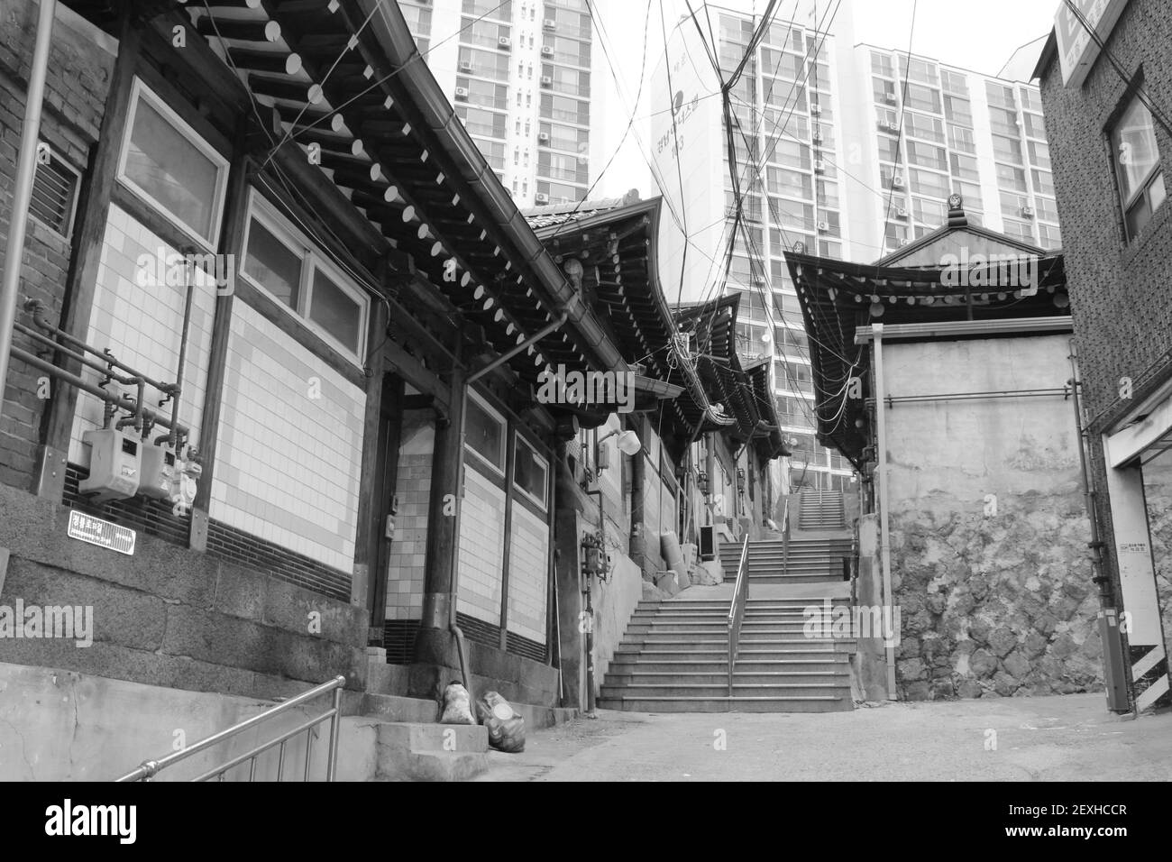 Old traditional Asian houses with modern condominium buildings, in black and white Stock Photo