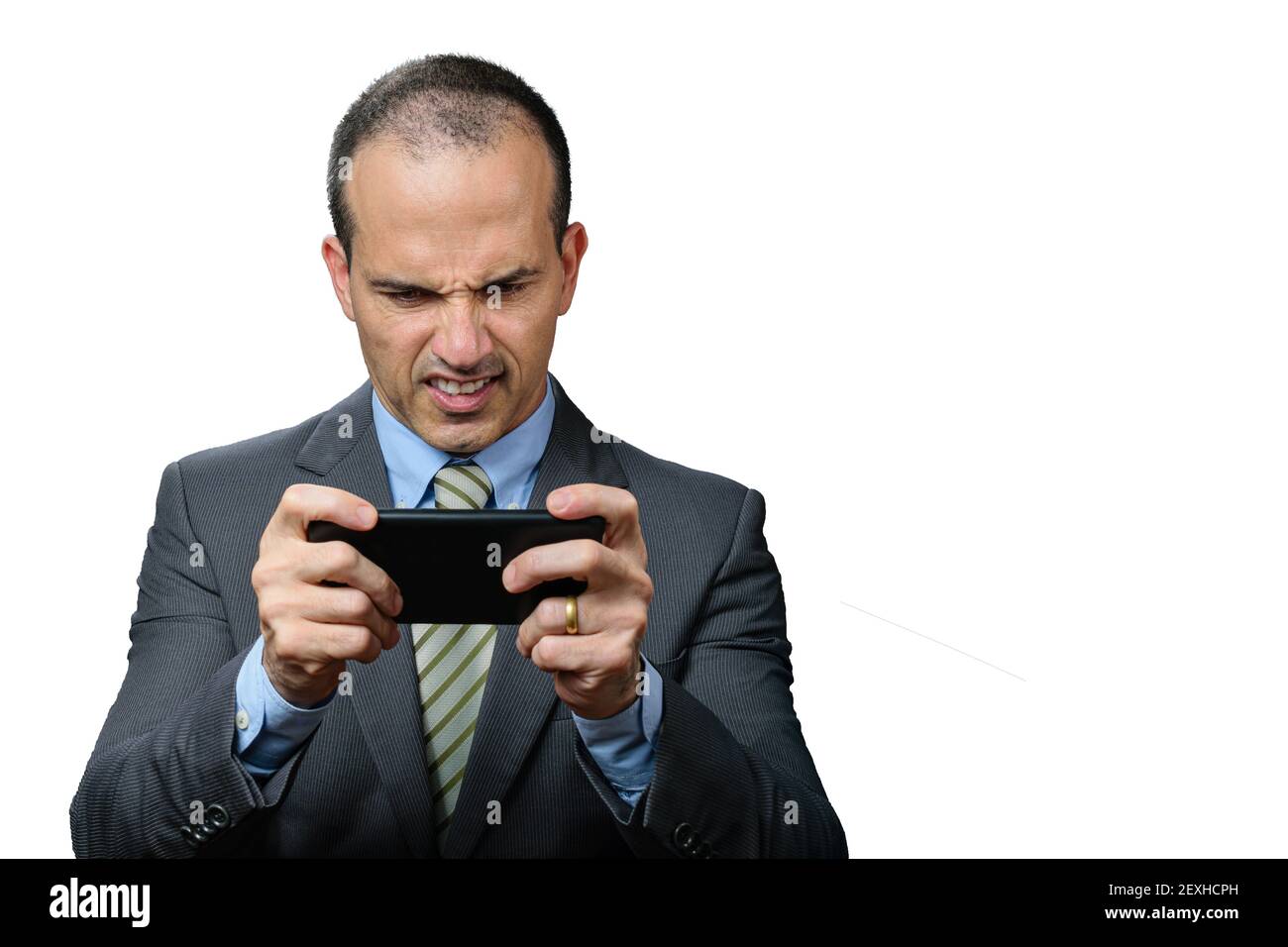 Mature man with suit and tie, playing on his smartphone and gritting his teeth. Stock Photo