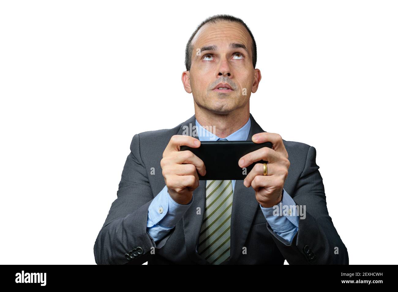 Mature man with suit and tie, holding his smartphone horizontally, worried and looking up. Stock Photo