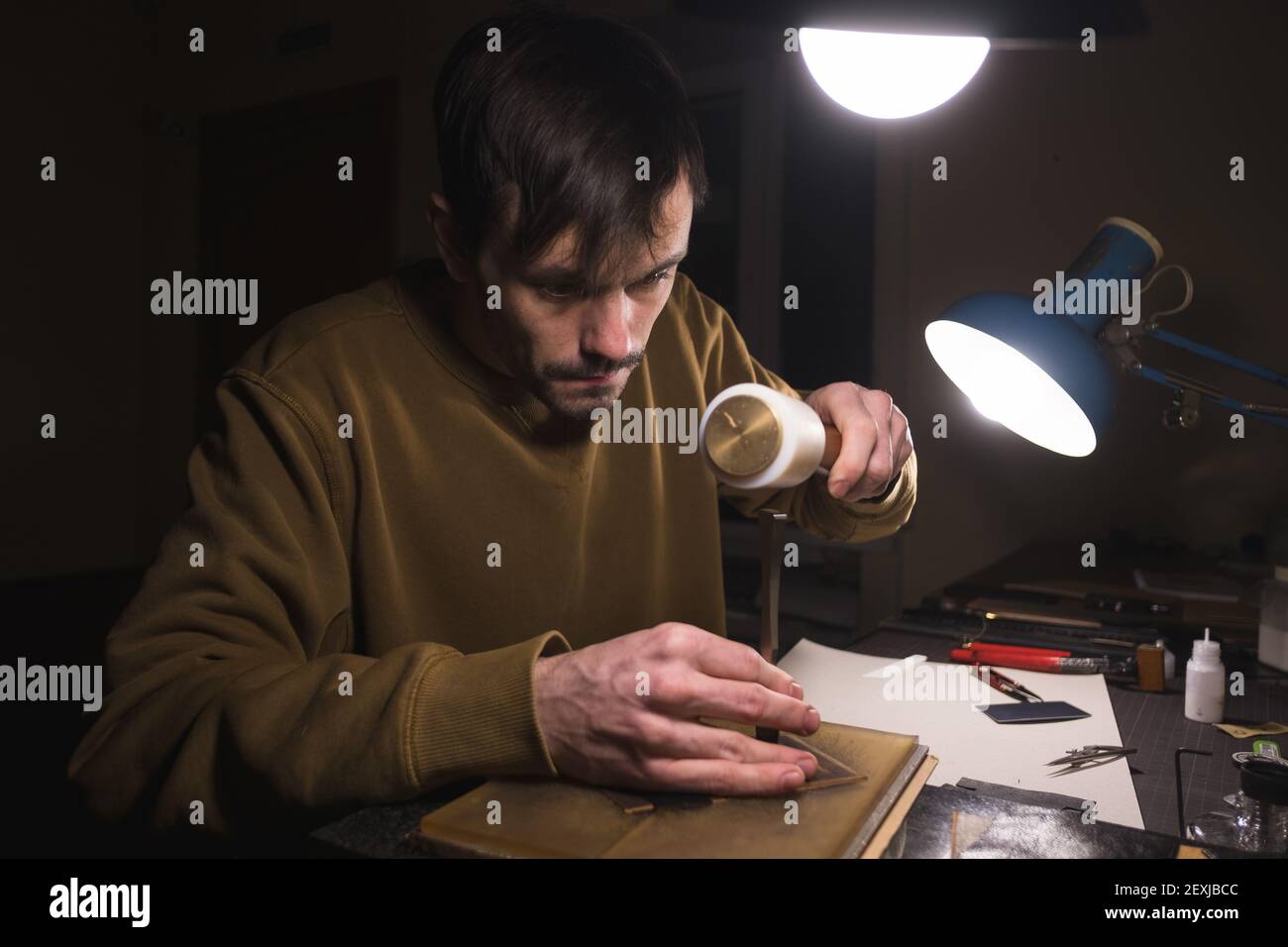 Making holes in leather with puncher tool Stock Photo Alamy