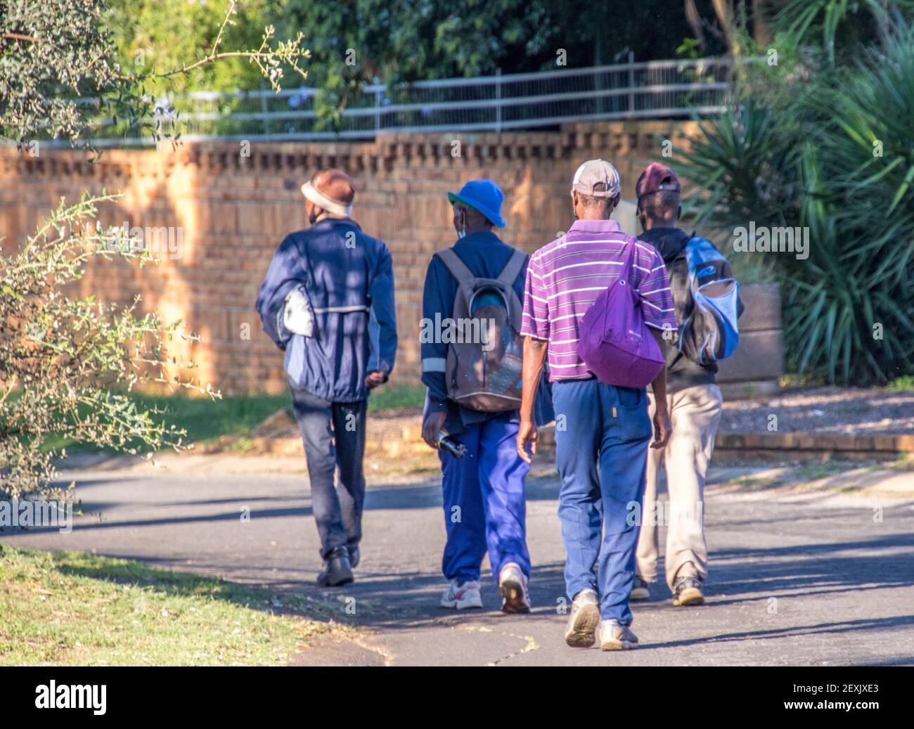 Johannesburg, South Africa - unidentified black workers walk to work as lockdown restrictions for the covid-19 pandemic are relaxed Stock Photo