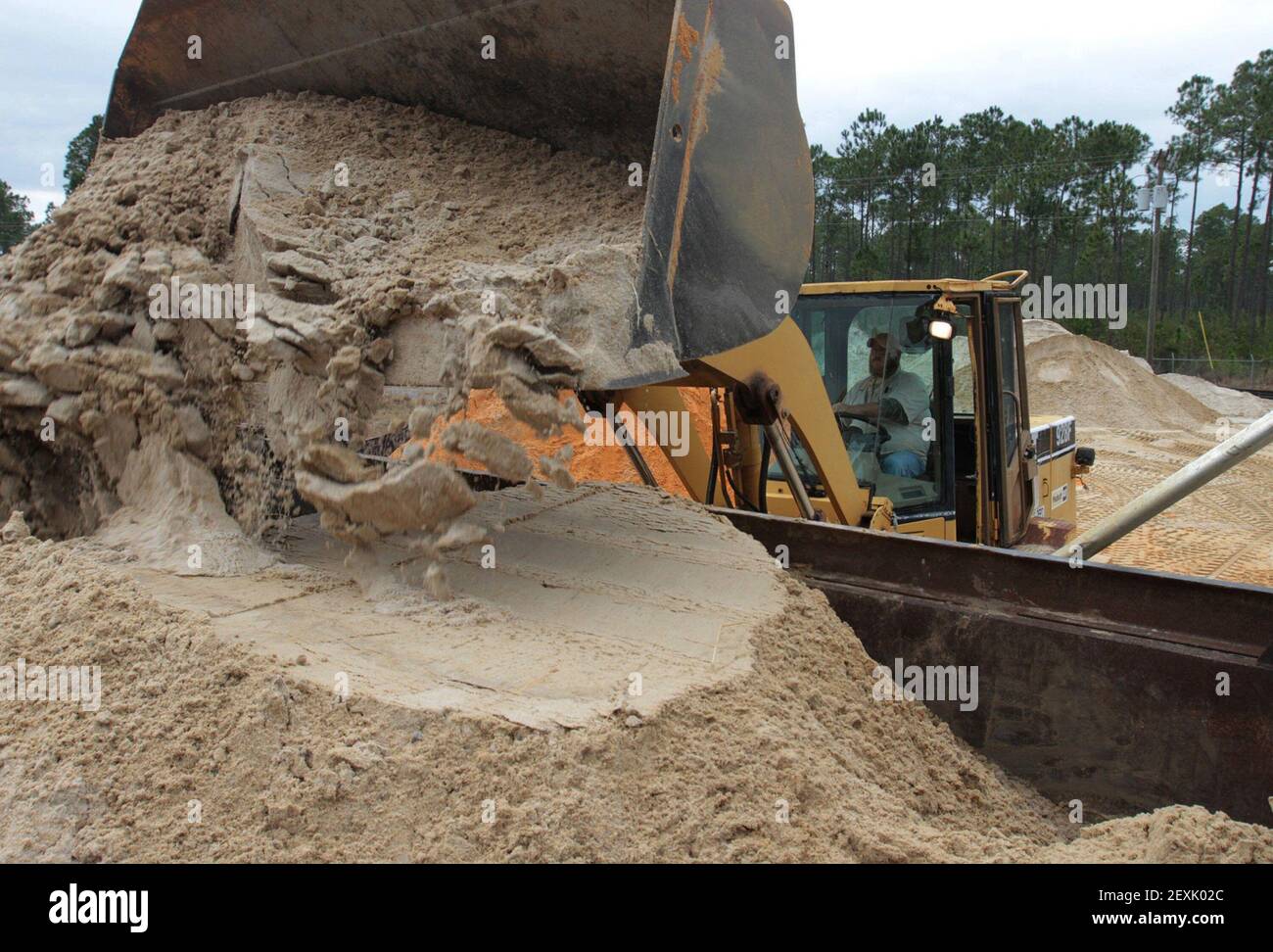 Tony Buckley of Vancleave, Miss., loads sand into a truck at the