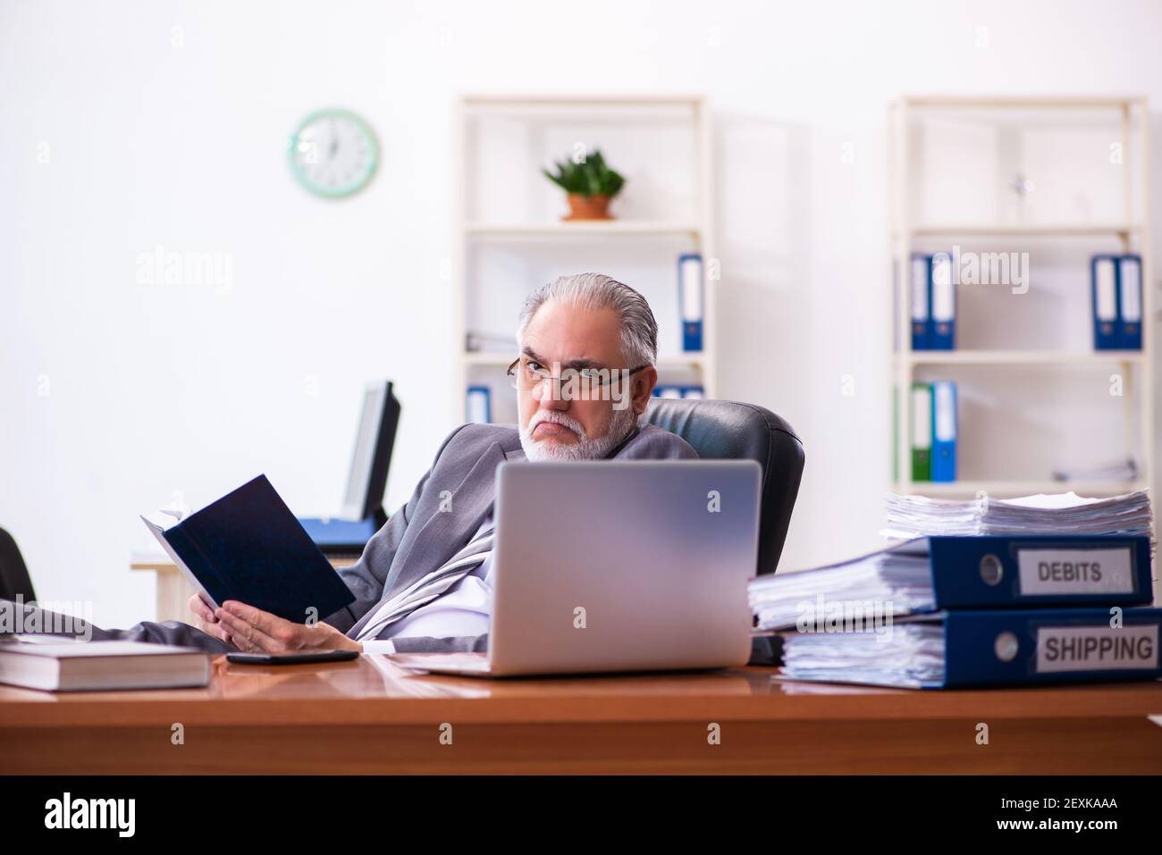 Senior male businessman employee reading guidelines in the office stock
