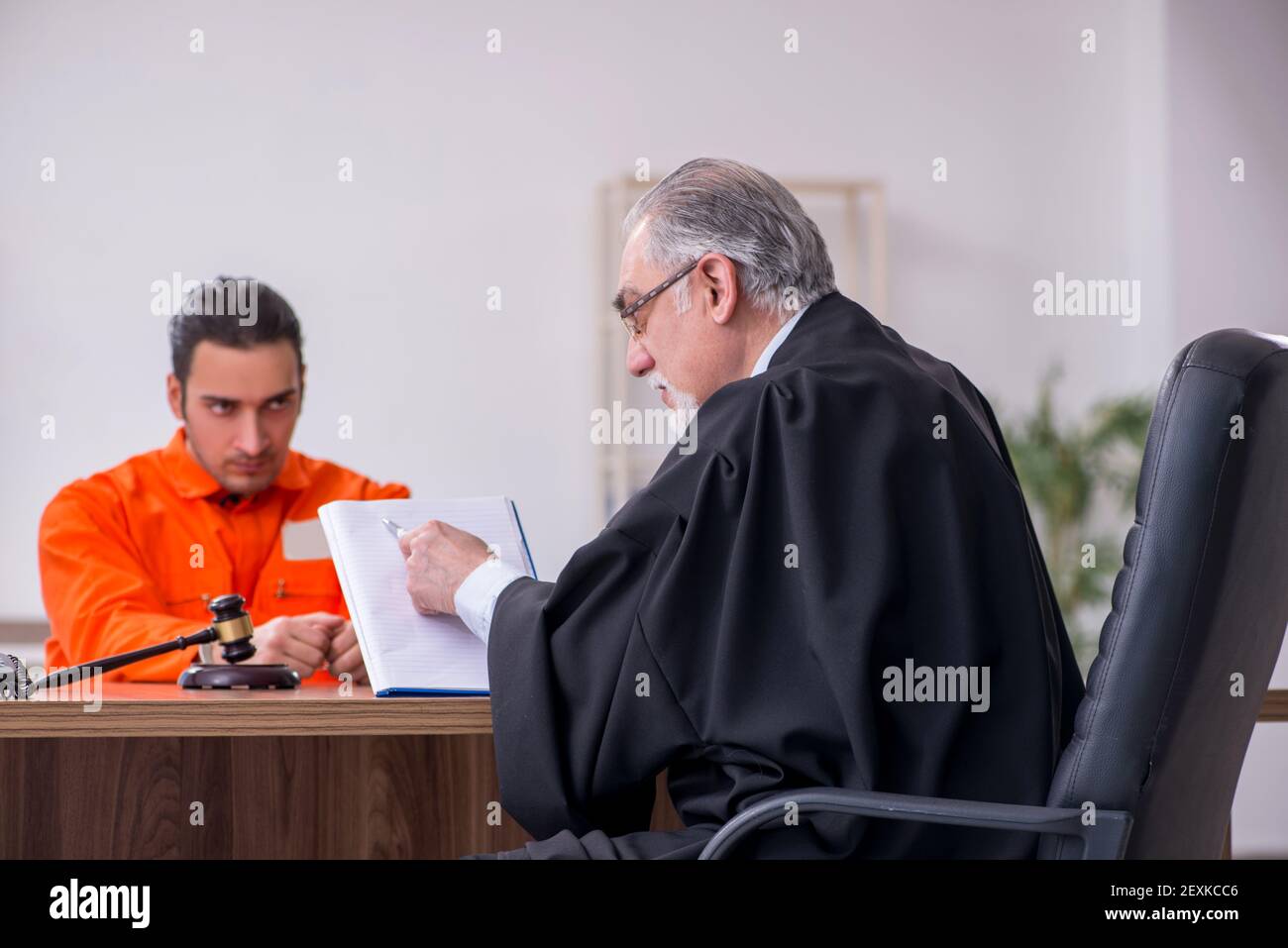 Old judge meeting with young captive in courthouse Stock Photo