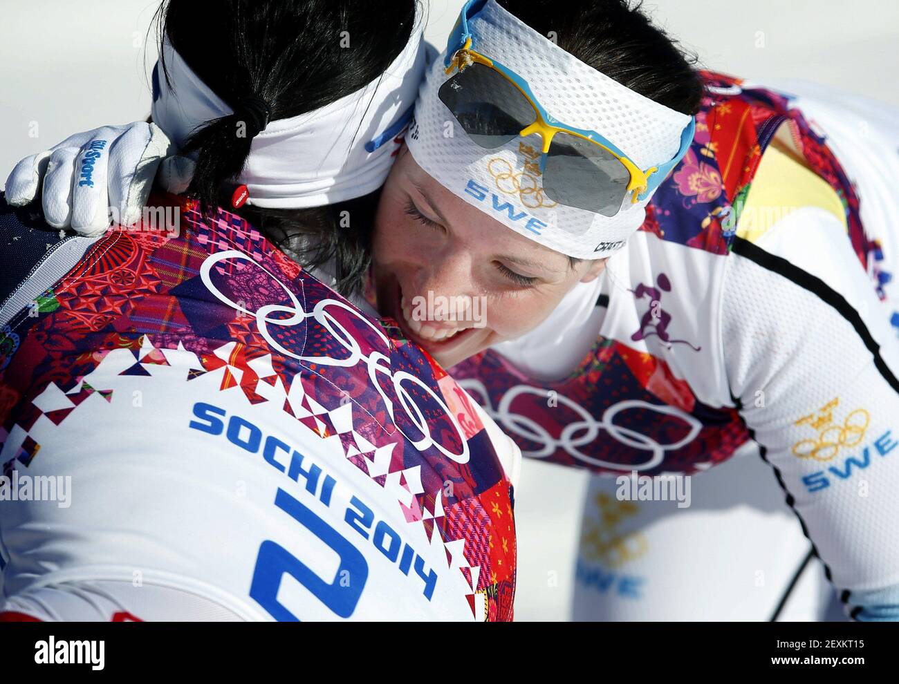 Marit Bjoergen of Norway, right, gets a hug from Charlotte Kalla of Sweden as she celebrates winning gold in the Women's 7.5m + 7.5m Skiathlon in the 2014 Winter Olympics in Sochi, Russia. (Photo by Carlos Gonzalez/Minneapolis Star Triubne/MCT/Sipa USA) Stock Photo