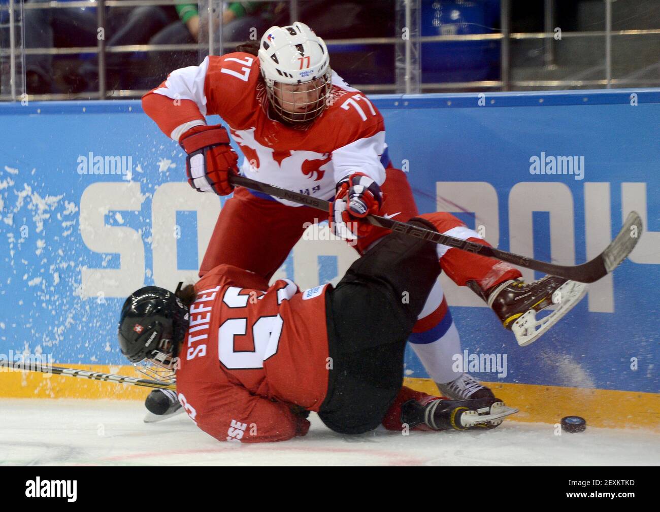 Russia defenseman Inna Dyubanok (77) and Switzerland forward Anja Stiefel  (63) collide while trying to play the puck in the first period of a women's  hockey quarter-final game at Shayba Arena during