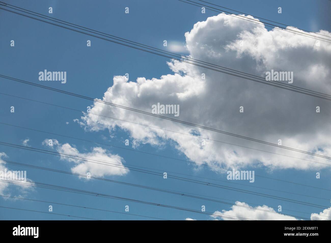 High voltage electricity power lines against blue cloudy sky Stock ...