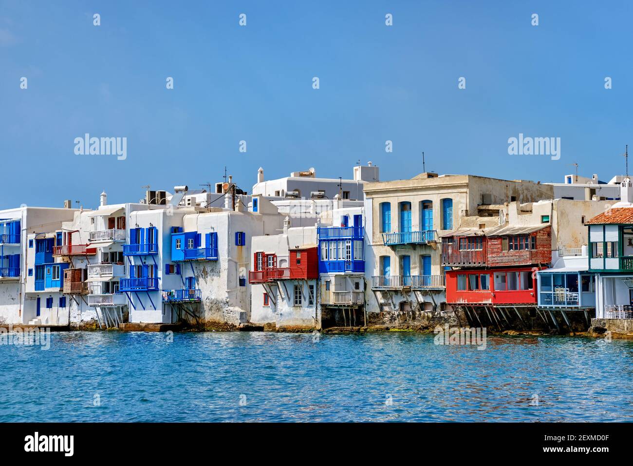 Seafront Little Venice of Mykonos town or Chora, Cyclades, Greece. Bars, cafes, restaurants in whitewashed old houses hang on cliffs above sea waves. Stock Photo