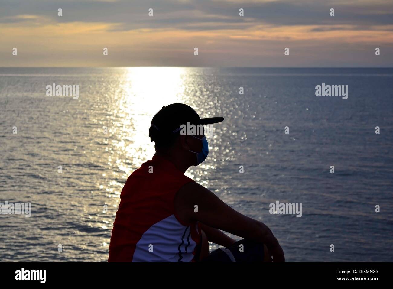 Man sitting on rock watching sunset hi-res stock photography and images ...