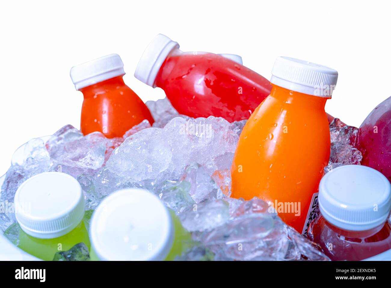 Organic cold pressed raw vegetable and fruit juice bottle in crushed ice bucket on white background. Healthy drink. Trendy juice beverage. Detox juice Stock Photo